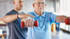 Physiotherapeut mit einem Senioren bei einer Übung